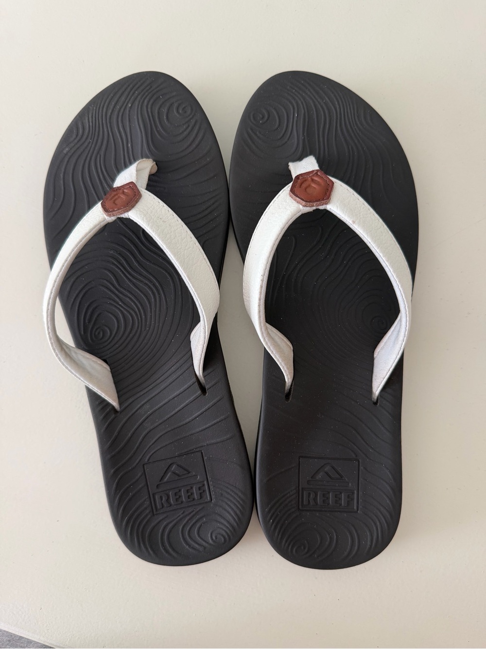 Reef Women’s Black Footbed Flip Flops with White Straps and Brown Logo Accent